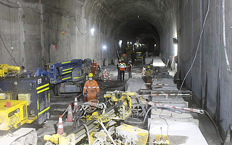 Vista aérea de la presa hidroelectrica evacuando agua rodeada de puestos hidroelectricos encargados de transportar la energía