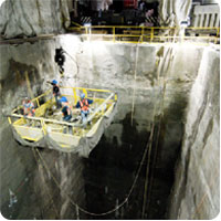 Imagen en donde se muestra una excavación en profundidad con un ascensor en donde están bajando una cuadrilla de operarios para la realización de sus tareas.